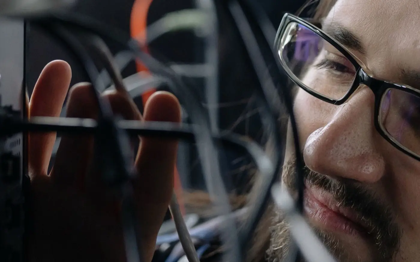 A technician connecting cables in a server rack